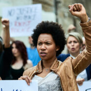African American woman with raised fist participating in a prote